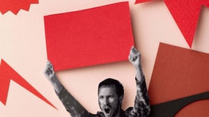 Collage artistico con una figura in bianco e nero di un uomo che esulta, sollevando un cartello rosso sopra la testa. Lo sfondo è composto da forme geometriche rosse e nere su una superficie color carne, evocando uno stile grafico e simbolico di rivoluzione.