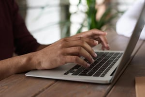 Persona che utilizza un pc portatile per scrivere una Newsletter
